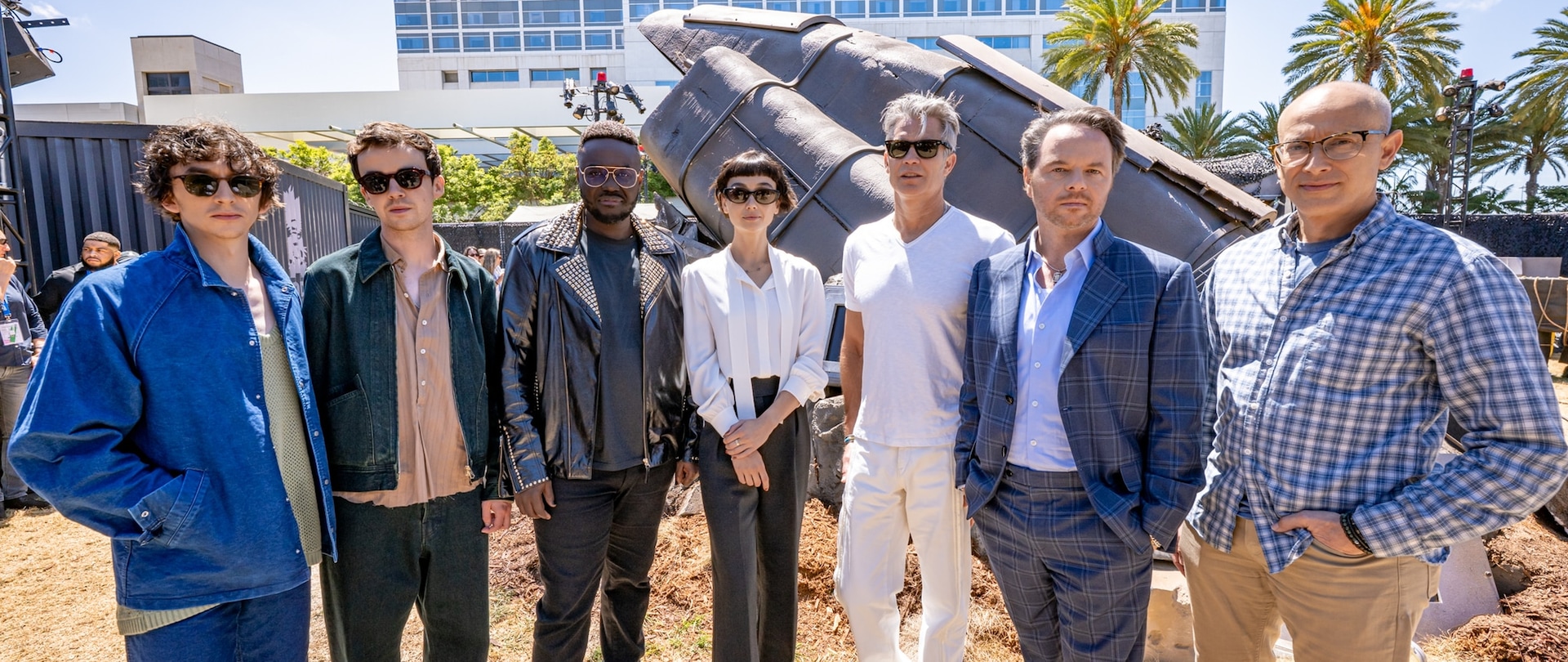 The Cast and Crew of FX's Alien: Earth standing in front of the SDCC Wreckage Activation.