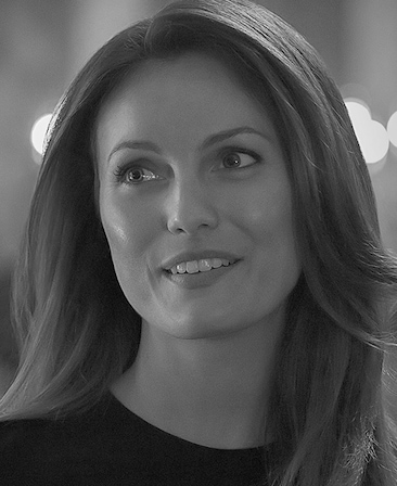 Black and white headshot of Leila George as Kelly Klein in FX's Love Story wearing a black tshirt.
