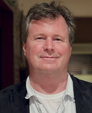 James W. Skotchdopole headshot wearing a white shirt and black jacket
