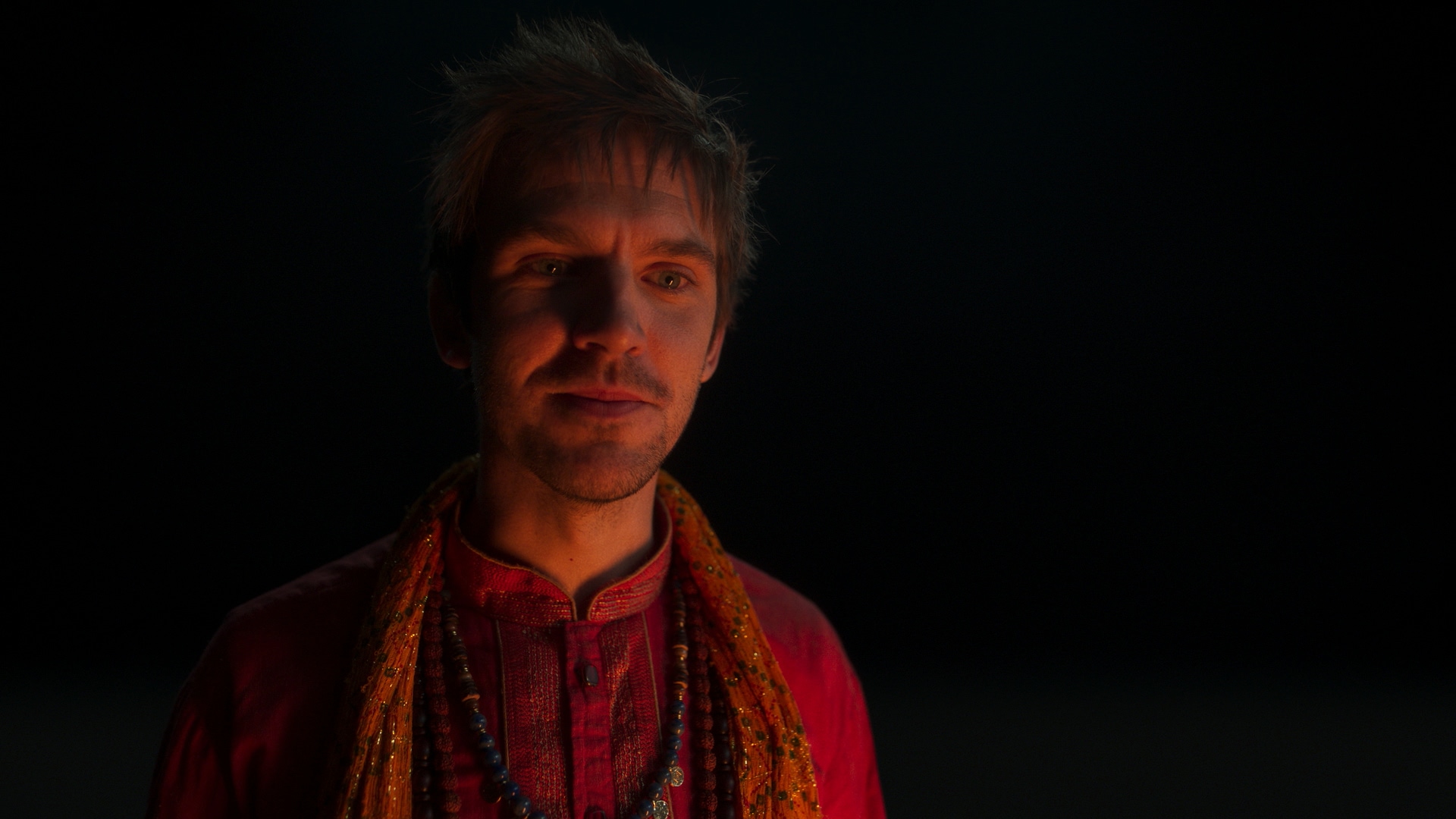 David wearing a red outfit in the dark for Legion