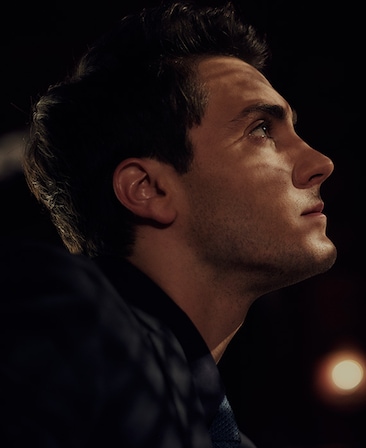 Noah Silver headshot wearing a black shirt and looking up