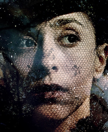 Oona Chaplin Headshot looking to the side with a fishnet veil over her face