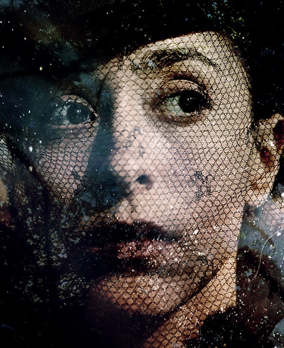 Oona Chaplin Headshot looking to the side with a fishnet veil over her face