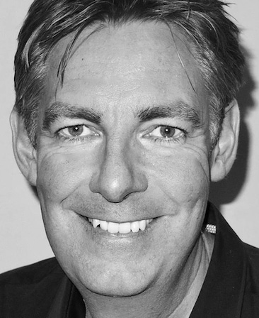Dean Baker Headshot smiling in a black and white filter