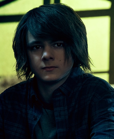 Max Charles Headshot wearing a black shirt and long black hair