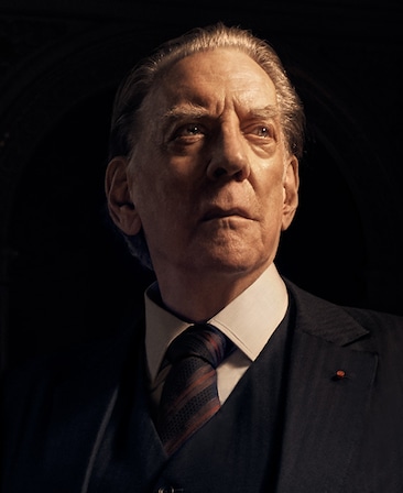 Donald Sutherland headshot wearing a suit with striped tie