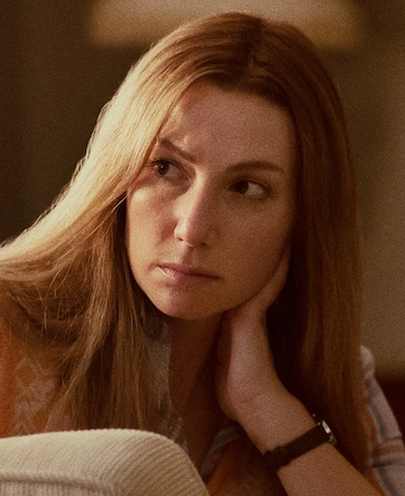 Ari Graynor headshot wearing a watch and wearing a plaid shirt