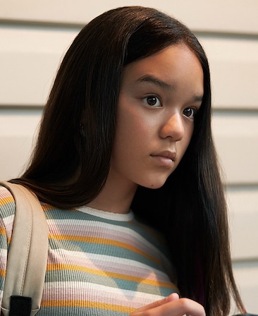 Chika Yasumura headshot wearing a orange and blue striped shirt 