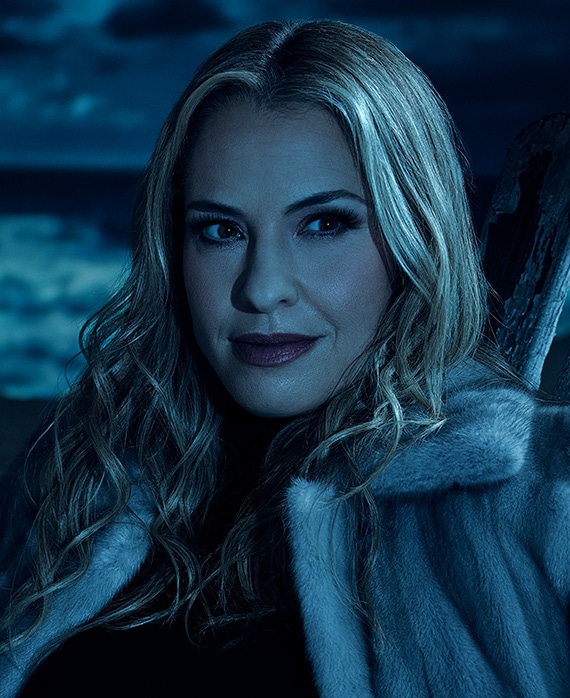 Headshot of Leslie Grossman in white fur jacket under moonlight on cloudy night from FX's AHS Double Feature