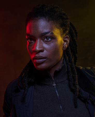 Ashley Romans headshot wearing a black zip up jacket