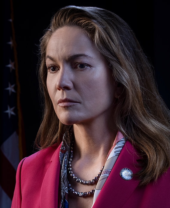 Diane Lane headshot wearing a pink blazer and beaded necklaces