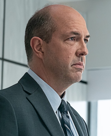 Eric Lange headshot wearing a gray suit and tie