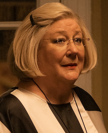 Headshot of Margo Martindale as Lucianne Goldberg in black and white striped shirt from FX's American Crime Story