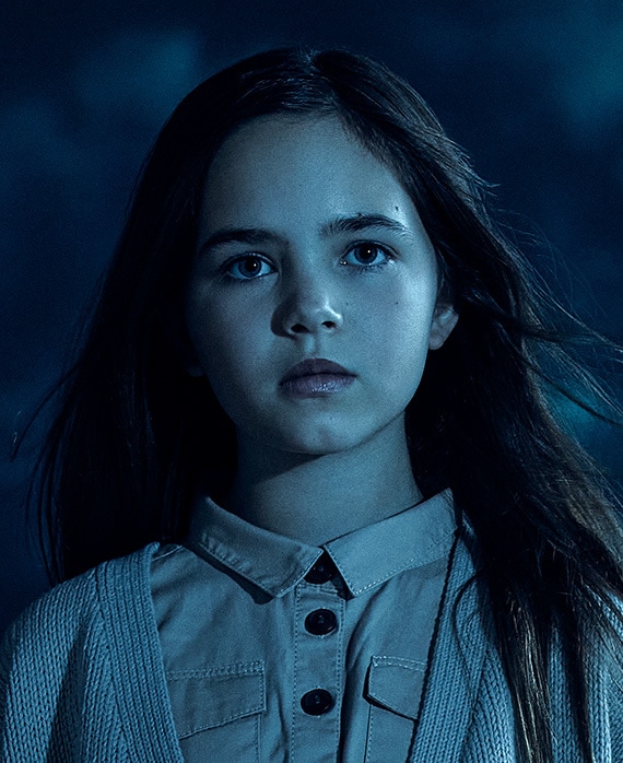 Headshot of Ryan Kiera Armstrong in white cardigan and shirt under moonlight on cloudy night from FX's AHS Double Feature