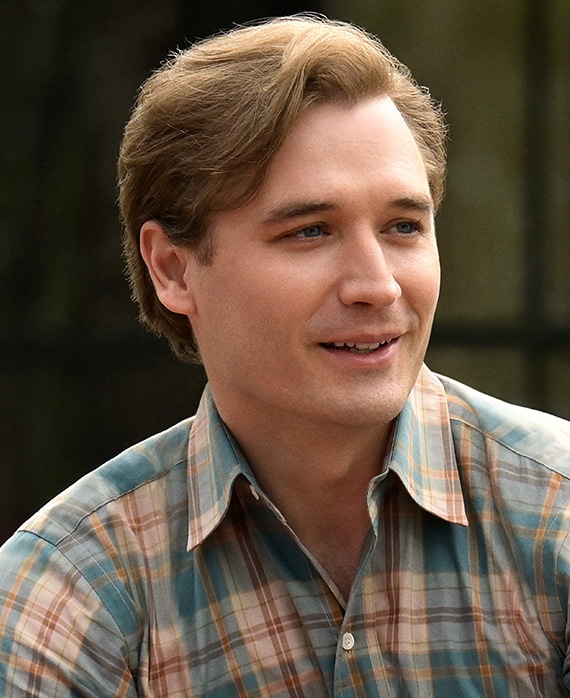 Seth Numrich headshot wearing a red and blue plaid shirt