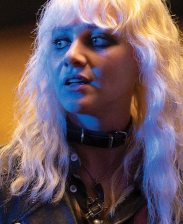 Emma Appleton headshot wearing a buckle necklace and black top