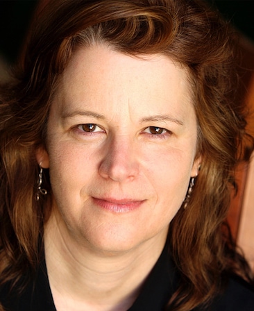 Hope Hartman headshot wearing a black top and earrings 