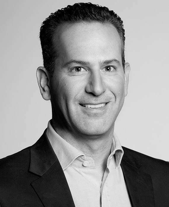 Black and white headshot of Darryl Frank in black suit and white button down against white background