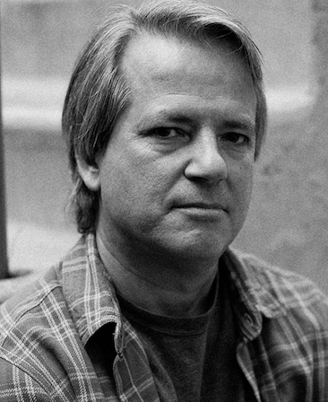 Black and white headshot of Graham Yost in plaid flannel over t shirt