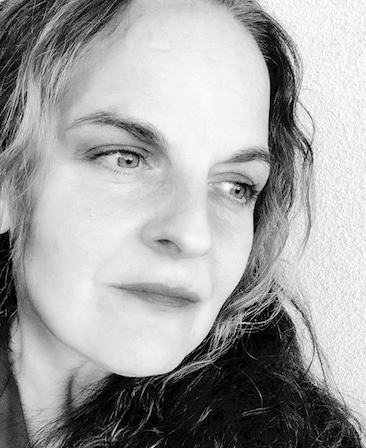 Regina Corrado Headshot looking to the side with a black and white filter