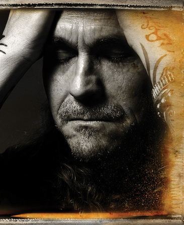 Kurt Sutter headshot holding his hands to his head