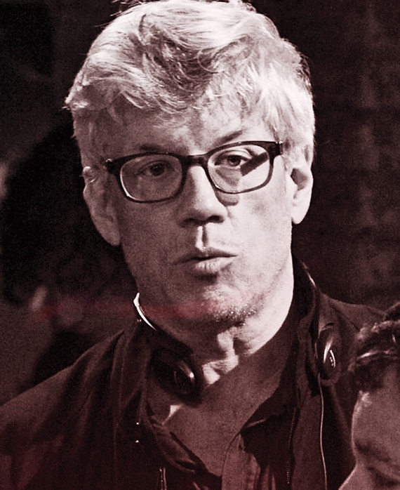 Leslie Tolan headshot wearing a black jacket and black glasses