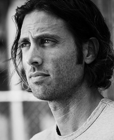 Brad Falchuk headshot wearing a gray shirt and standing outside