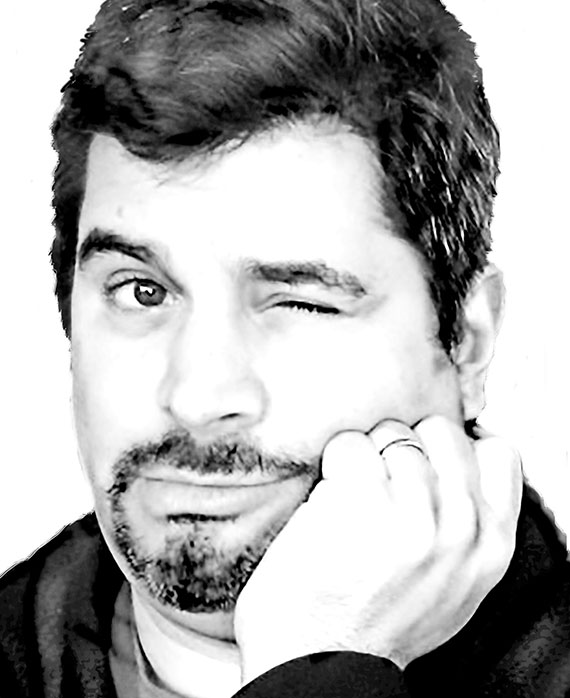Ari Posner headshot placing his hand on his cheek and winking with one eye
