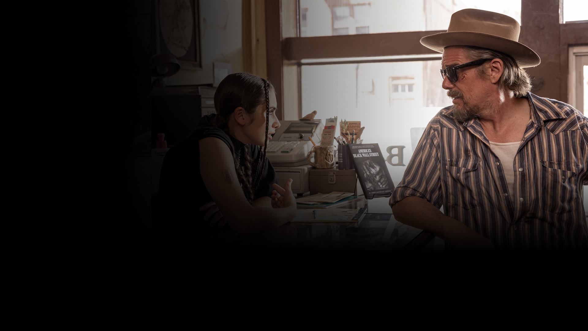 Ethan Hawke wearing a striped shirt and brown hat for FX's The Lowdown.
