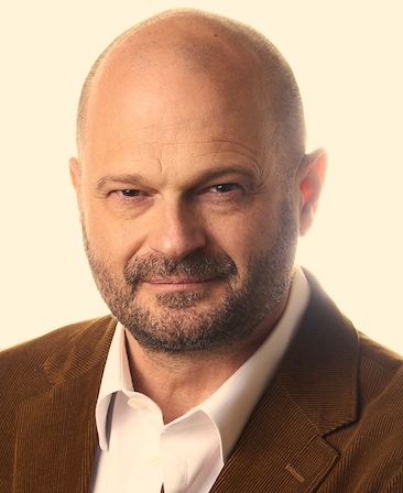 Headshot of executive producer Brad Simpson of FXs Love Story wearing a white button up and brown corduroy suit.