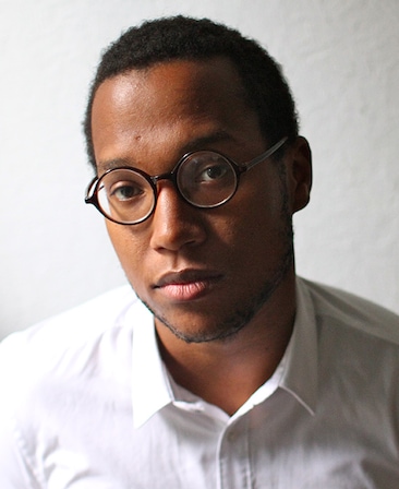 Branden Jacobs-Jenkins headshot in white button down and round glasses in natural lighting against plain white background