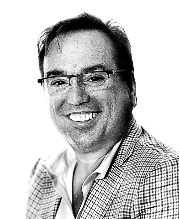 Peter Principato headshot wearing a plaid shirt and glasses