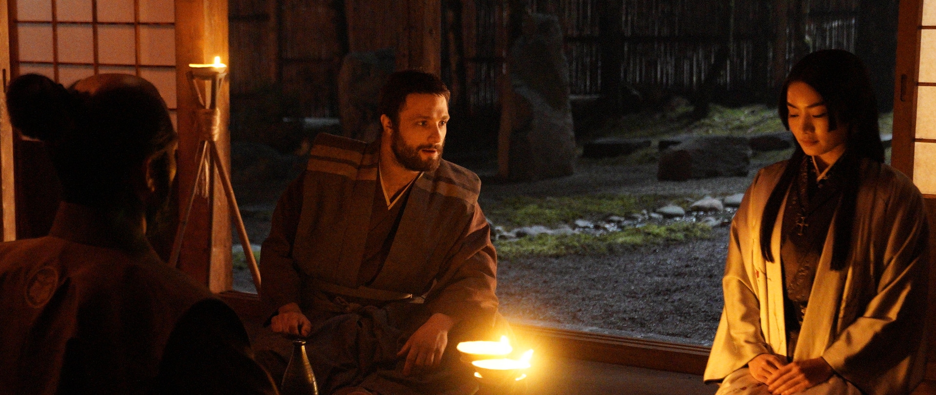 Blackthorne speaks with Mariko in a torch lit room on the set of FX’s Shogun